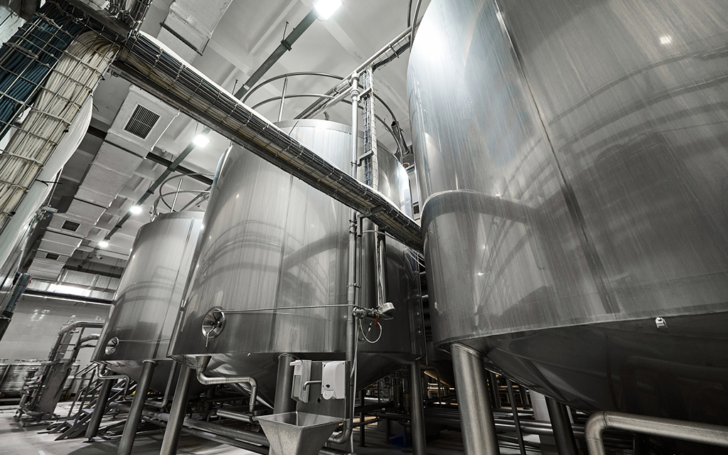 Large stainless steel fermentation tanks inside an industrial brewery